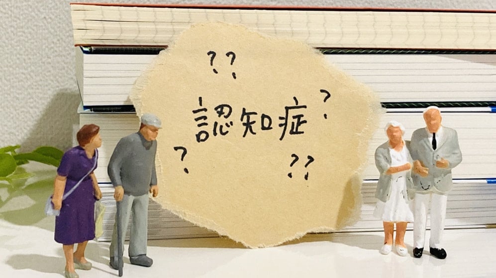 認知症と書かれたテキストと高齢者の人形